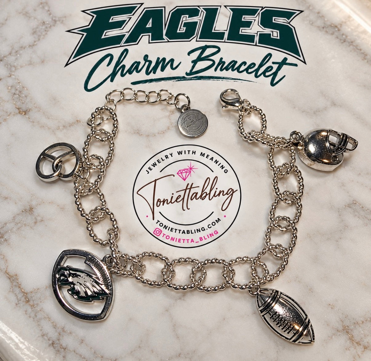 Silver charm bracelet with eagle, football, helmet and soft pretzel charms on a marble plate